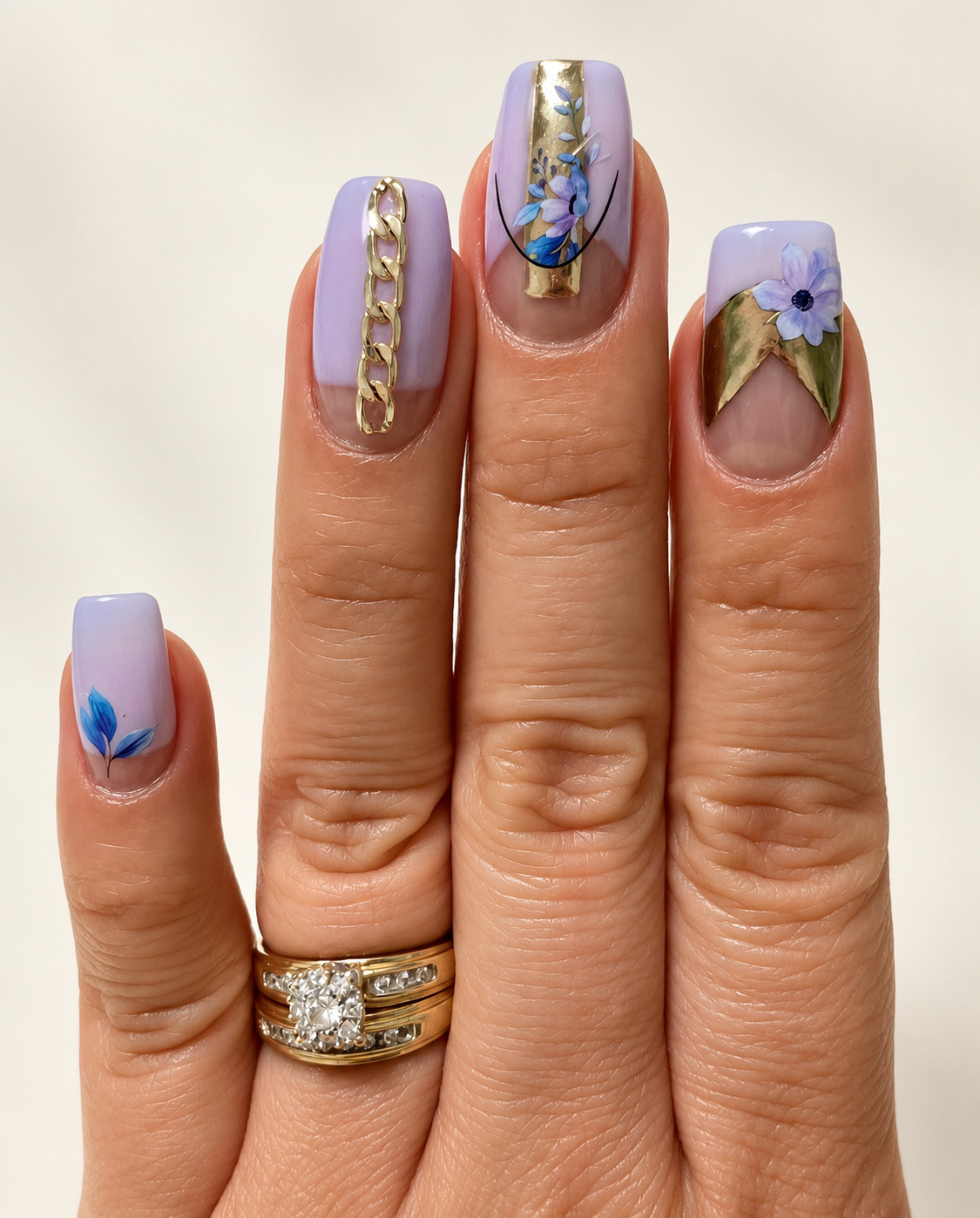 Lavender square nails with blue painted flowers, gold foil and chain details